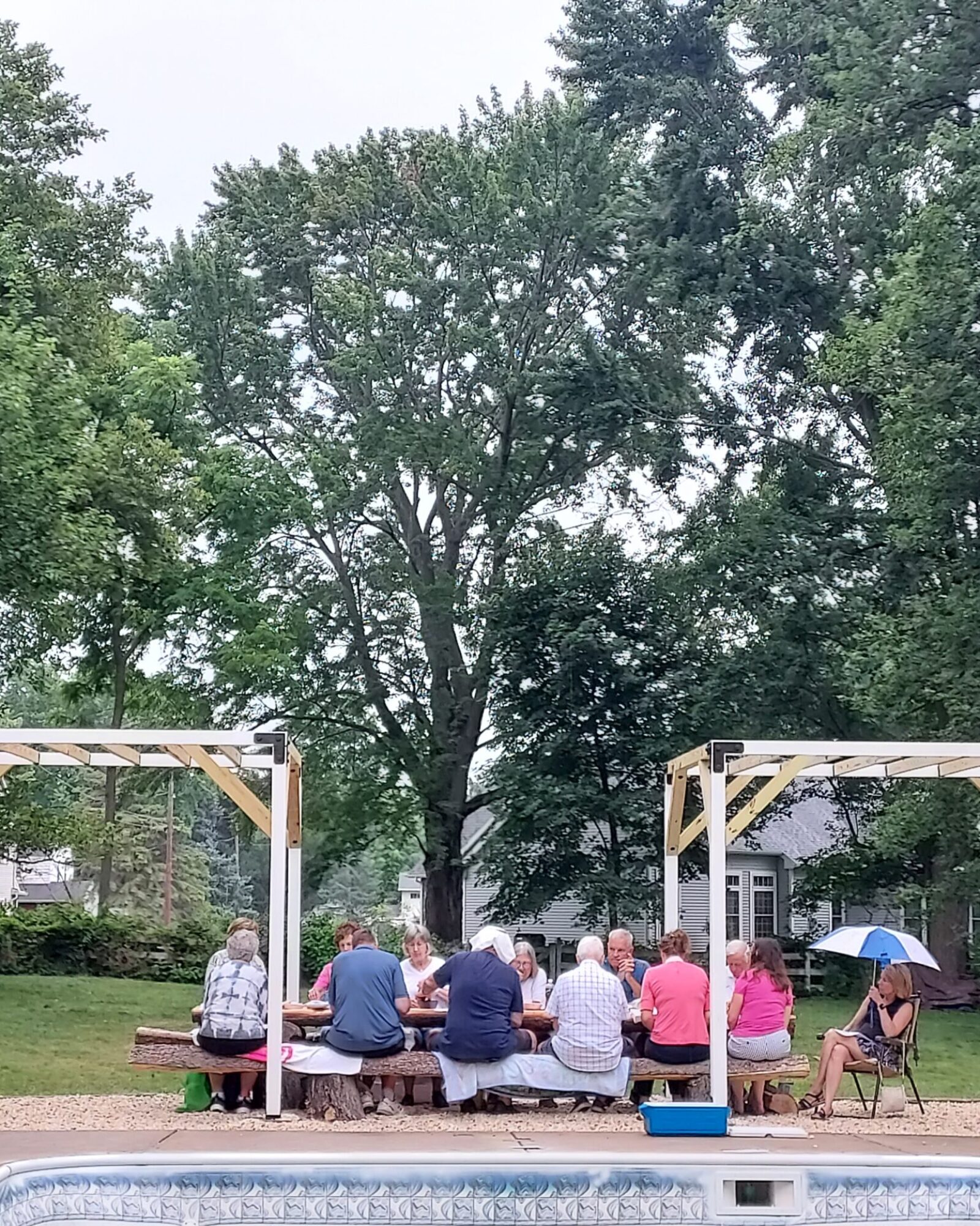small group sits at picnic table outside
